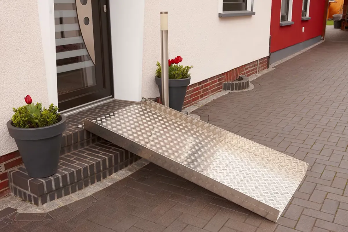 Klapprampe von Bremen Lifte steht Aufgebaut vor einer Haustür um die Stufe davor zu überwinden